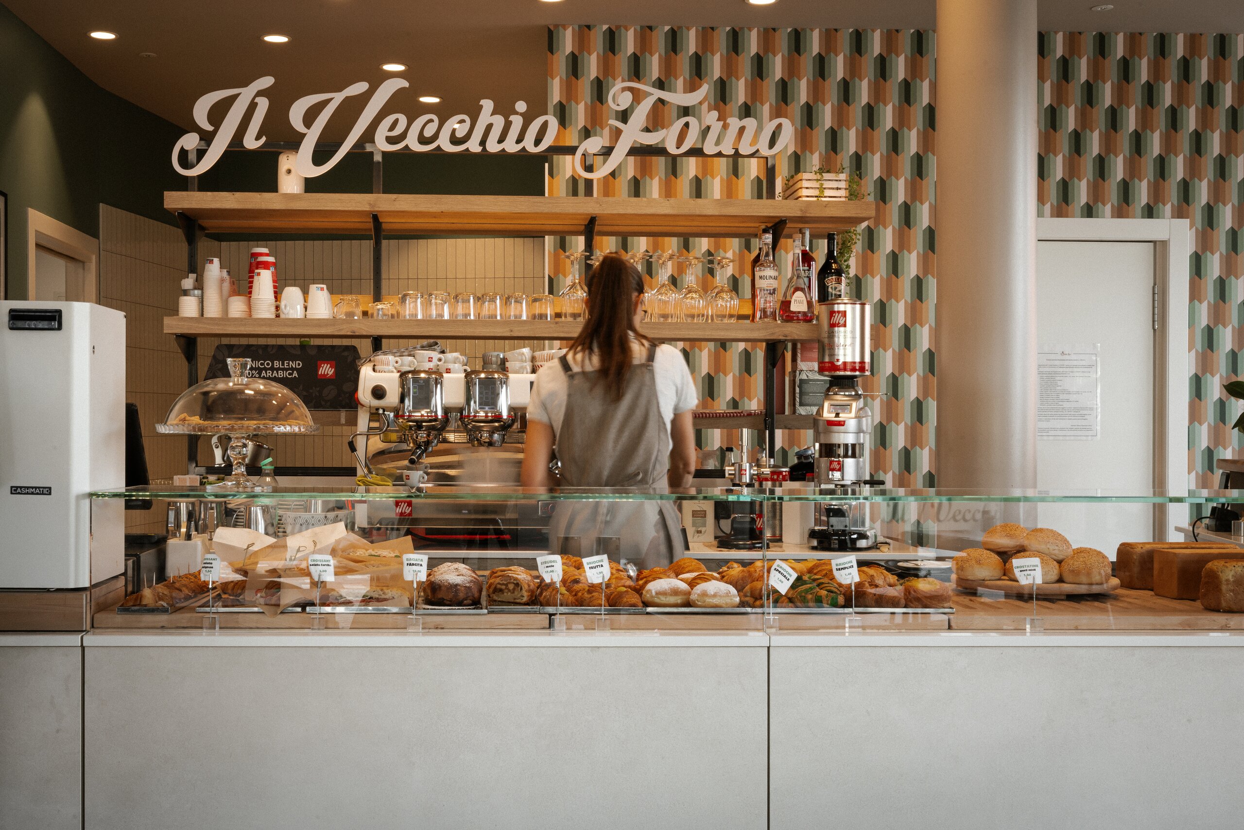 Bancone caffetteria del Vecchio Forno con insegna, brioche e pane in vetrina