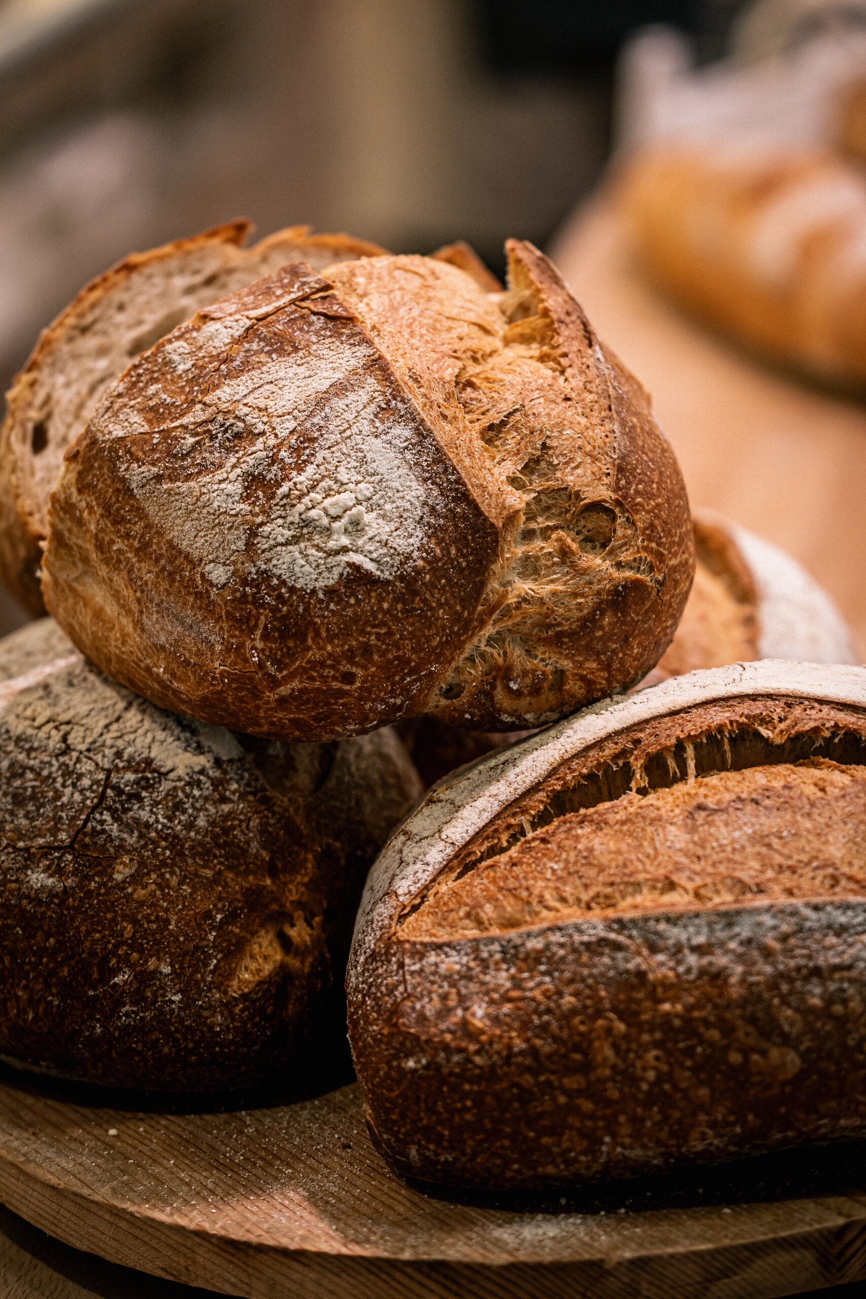 Pagnotte di pane artigianale impilate su un tagliere di legno