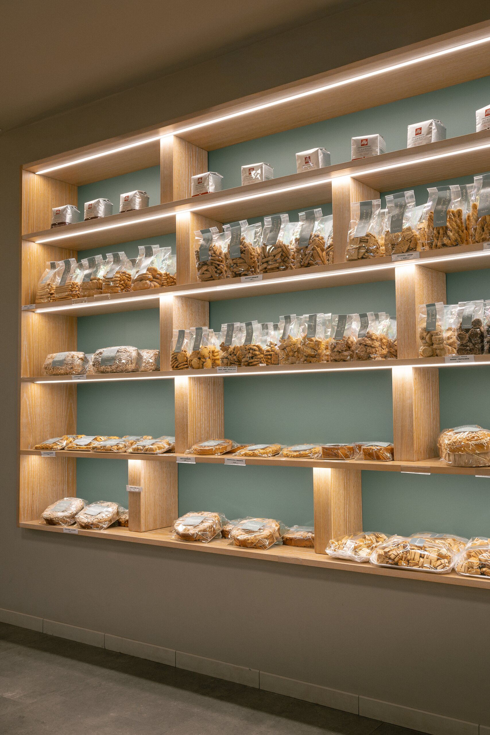 Scaffale illuminato con biscotti e dolci confezionati con etichette Vecchio Forno
